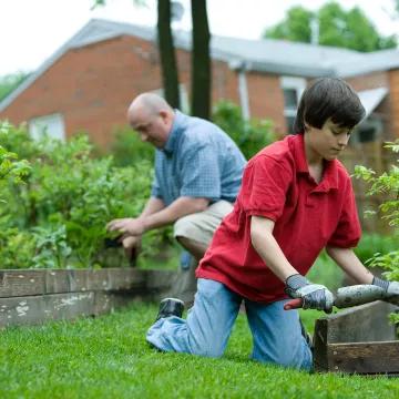 Young boy and grandfather gardening